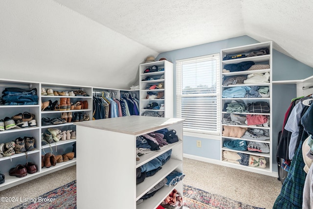 spacious closet featuring vaulted ceiling and carpet flooring