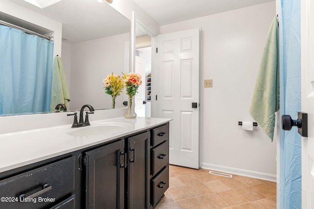 bathroom featuring vanity, a textured ceiling, and tile patterned floors