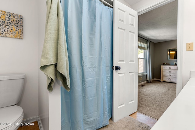 bathroom featuring a textured ceiling, toilet, and tile patterned floors