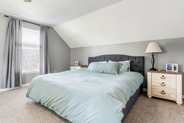 carpeted bedroom featuring a textured ceiling and lofted ceiling