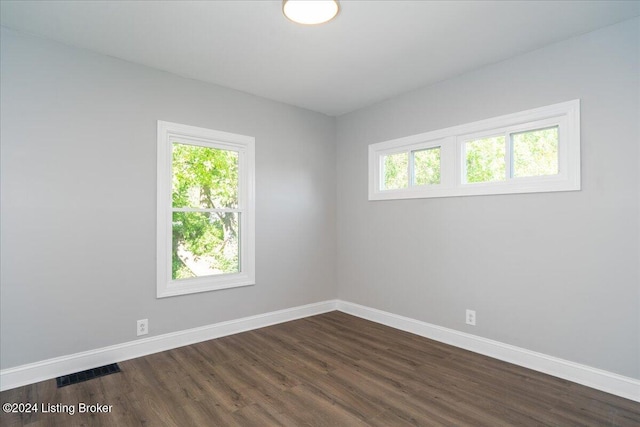 empty room with dark hardwood / wood-style flooring