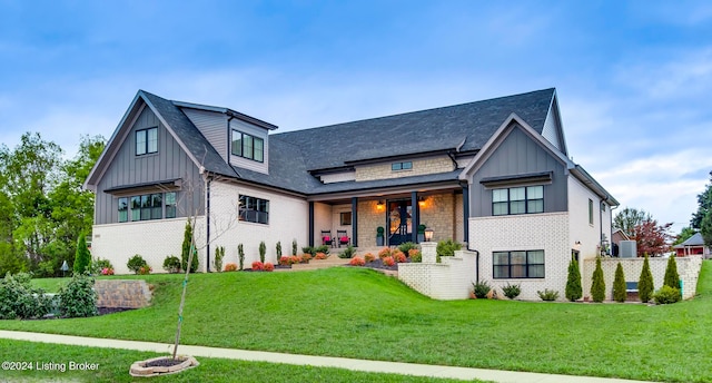 modern inspired farmhouse with a front lawn, central air condition unit, and covered porch