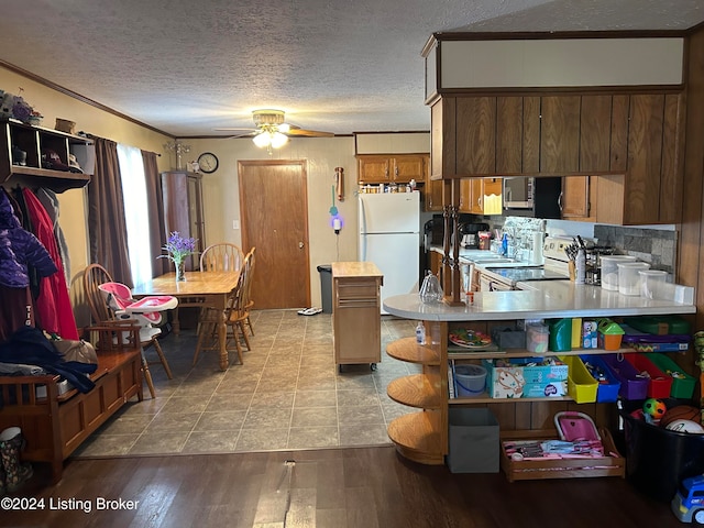 kitchen featuring kitchen peninsula, decorative backsplash, white appliances, ceiling fan, and light hardwood / wood-style floors