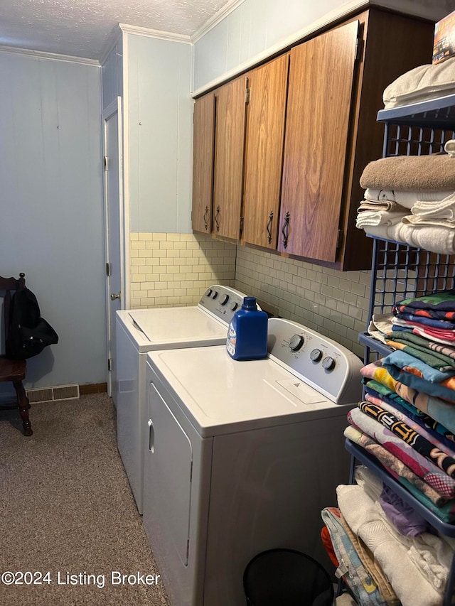 clothes washing area featuring cabinets, separate washer and dryer, and crown molding