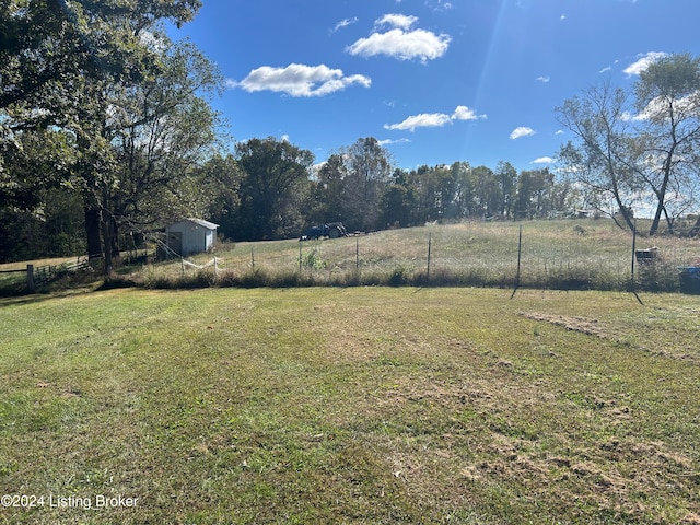 view of yard featuring a rural view and a shed