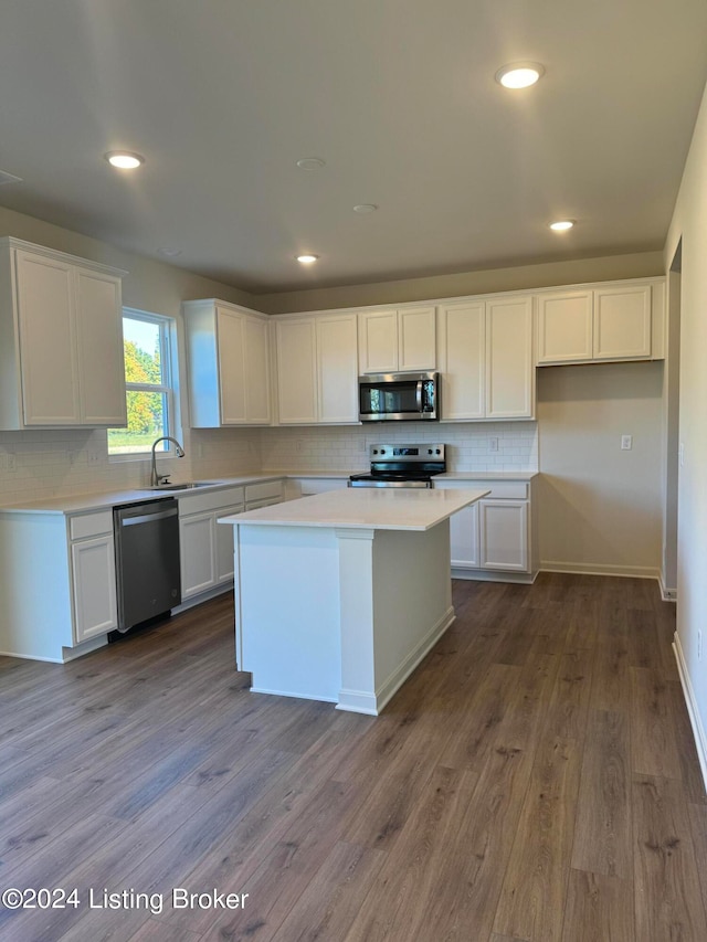 kitchen with appliances with stainless steel finishes, white cabinets, and dark hardwood / wood-style flooring