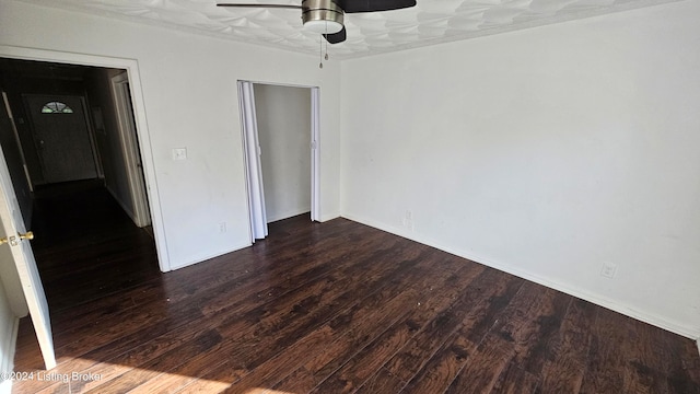 unfurnished bedroom featuring dark wood-type flooring and ceiling fan