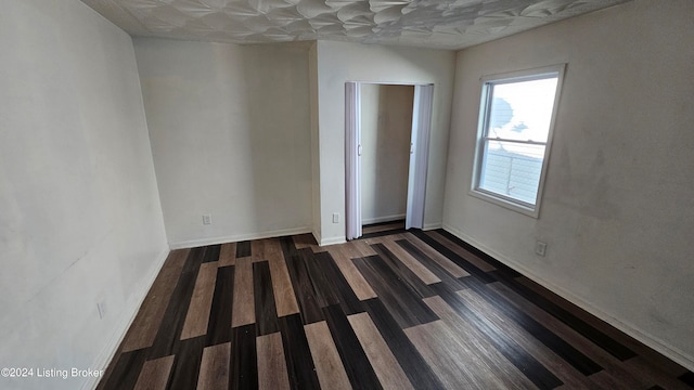 empty room with dark wood-type flooring