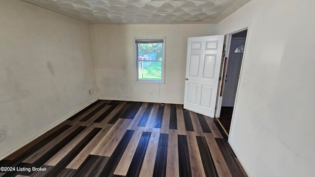 unfurnished room featuring dark wood-type flooring