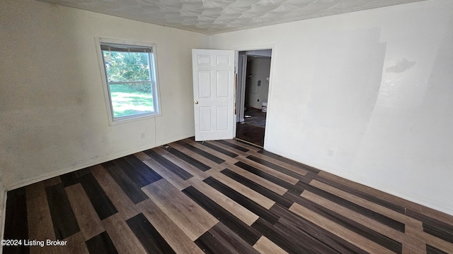 empty room with dark hardwood / wood-style flooring