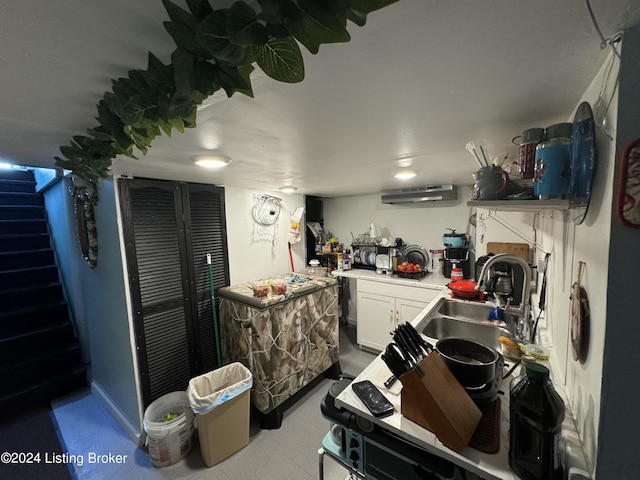 kitchen with white cabinetry, sink, and exhaust hood