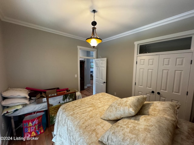 bedroom with a closet, wood-type flooring, and ornamental molding