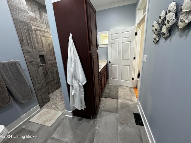 bathroom with vanity, crown molding, toilet, and a shower