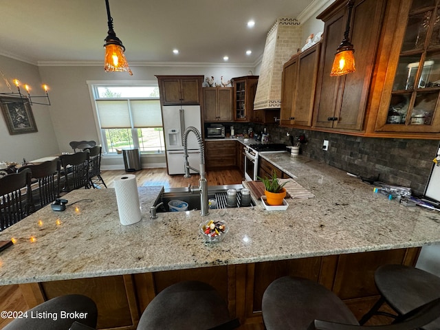 kitchen featuring light hardwood / wood-style floors, high end stainless steel range oven, white refrigerator with ice dispenser, and pendant lighting