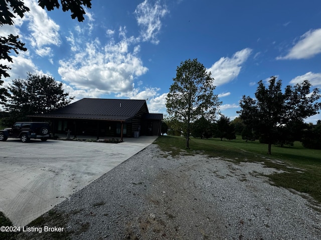 view of property exterior with a lawn and a carport