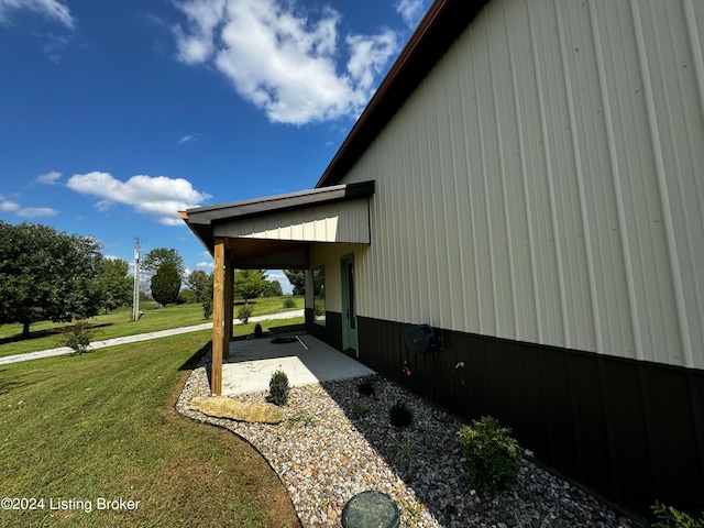 view of side of property with a patio area and a yard