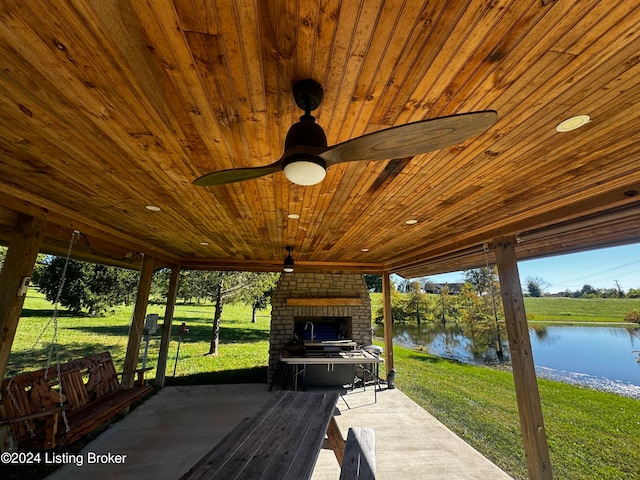 deck featuring a patio, a yard, a water view, and ceiling fan