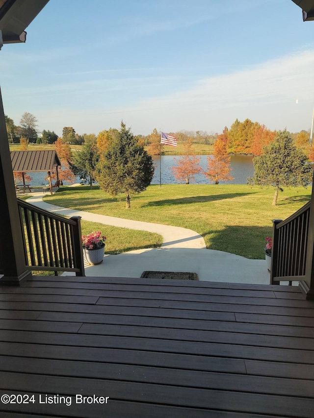 deck featuring a patio area, a yard, and a water view