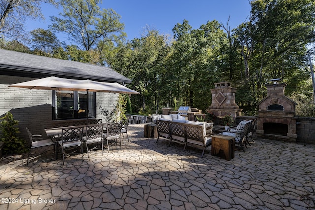 view of patio / terrace with outdoor dining space and an outdoor living space with a fireplace