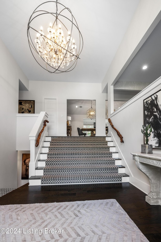 stairway with a chandelier and wood finished floors