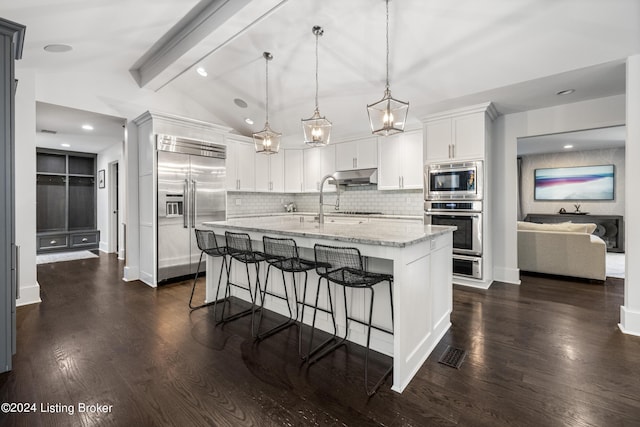 kitchen with built in appliances, dark wood-type flooring, lofted ceiling with beams, and under cabinet range hood