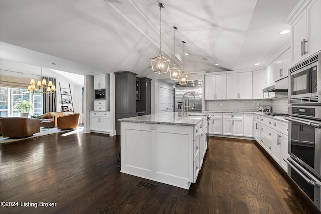 kitchen featuring built in appliances, a notable chandelier, a sink, vaulted ceiling, and a warming drawer