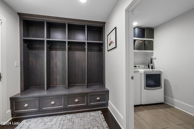 mudroom with baseboards, washing machine and clothes dryer, and wood finished floors