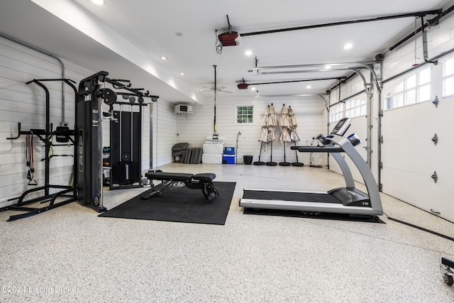 workout area with a garage, a wall mounted AC, and recessed lighting