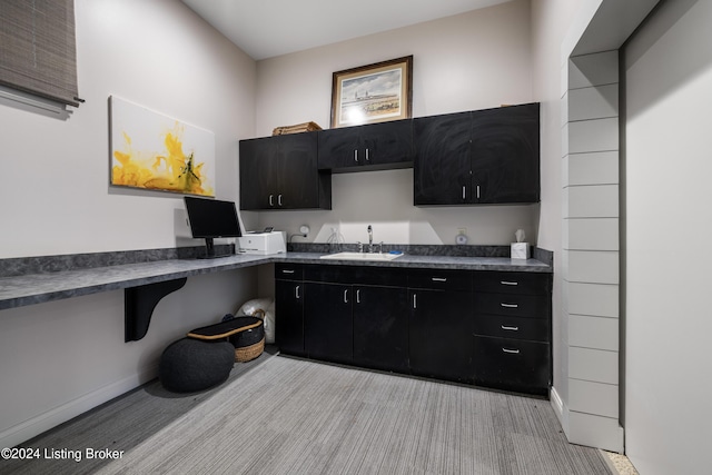 kitchen featuring dark countertops, dark cabinets, and a sink