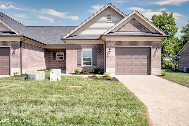 view of front facade featuring a garage, a front yard, and central AC unit