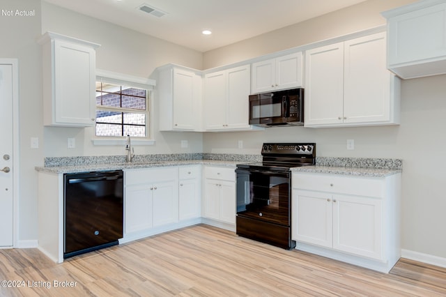 kitchen featuring light wood-type flooring, sink, light stone countertops, white cabinets, and black appliances