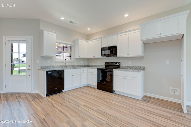 kitchen with black appliances, a wealth of natural light, white cabinetry, and light hardwood / wood-style flooring