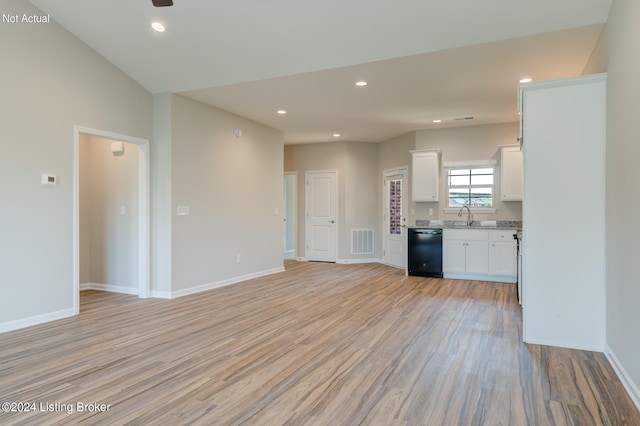 unfurnished living room featuring sink and light hardwood / wood-style floors