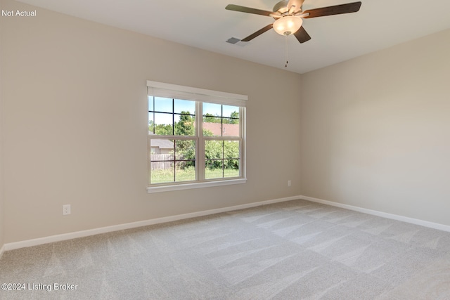 spare room featuring light carpet and ceiling fan