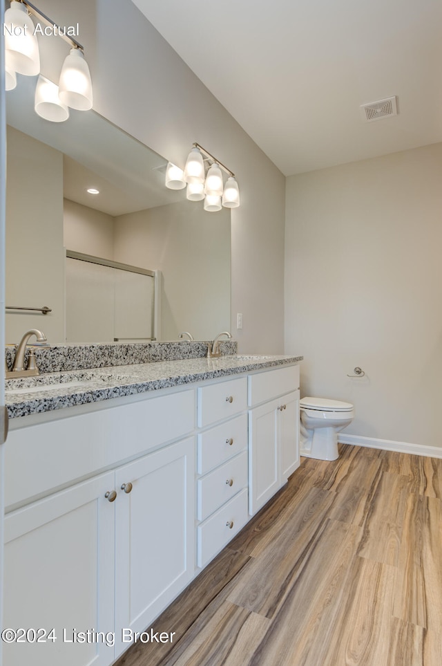 bathroom featuring vanity, toilet, a shower with door, and hardwood / wood-style flooring