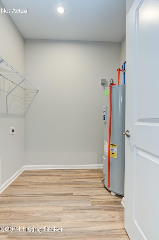 clothes washing area with wood-type flooring, electric water heater, and hookup for an electric dryer