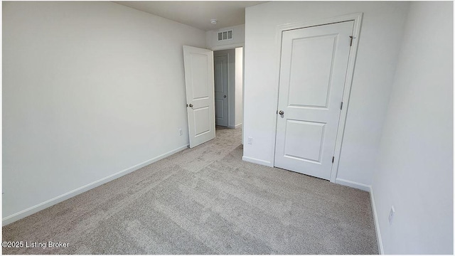 unfurnished bedroom with carpet flooring, baseboards, and visible vents