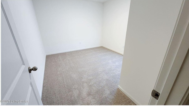 carpeted spare room featuring baseboards