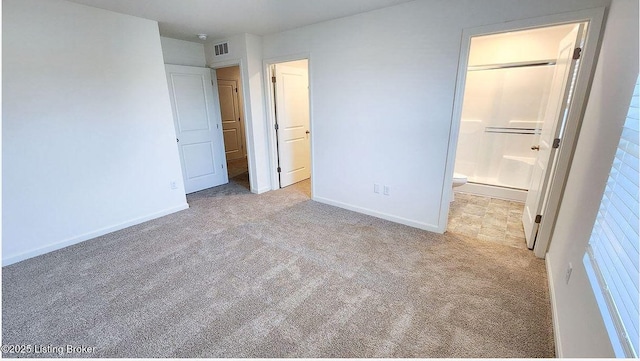 unfurnished bedroom featuring ensuite bathroom, visible vents, baseboards, and carpet floors