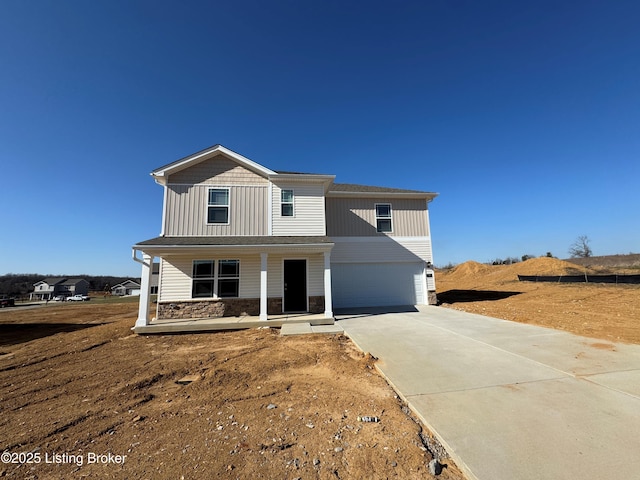 view of front facade featuring stone siding, covered porch, board and batten siding, concrete driveway, and a garage