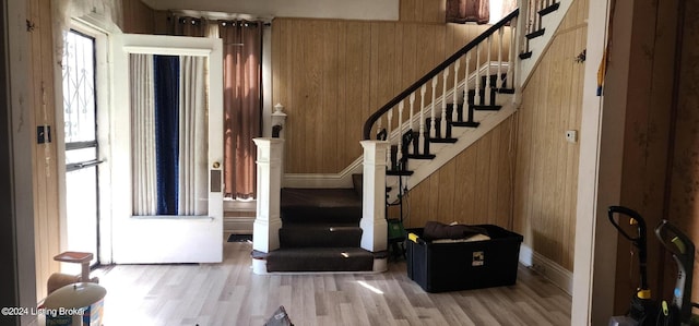 staircase with wood-type flooring and wood walls