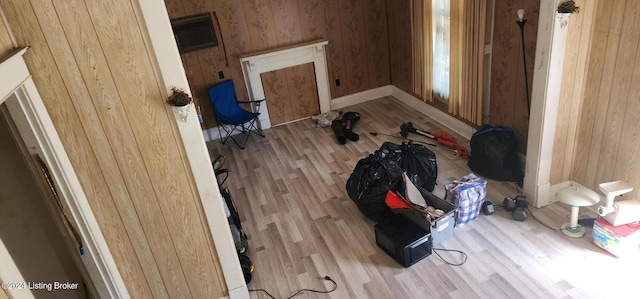 clothes washing area with wooden walls and light hardwood / wood-style flooring