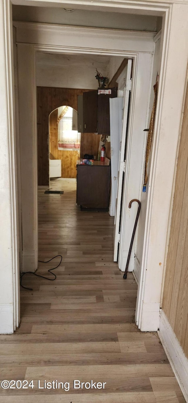 corridor featuring wood walls and light hardwood / wood-style floors