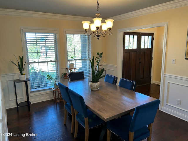 dining space featuring ornamental molding, a notable chandelier, and dark wood-type flooring