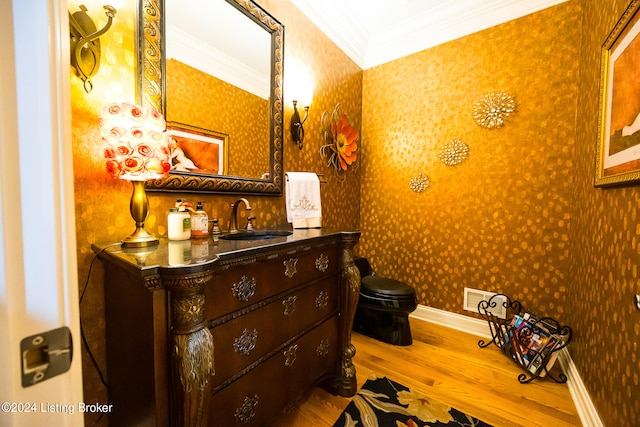 bathroom featuring hardwood / wood-style floors, vanity, toilet, and ornamental molding