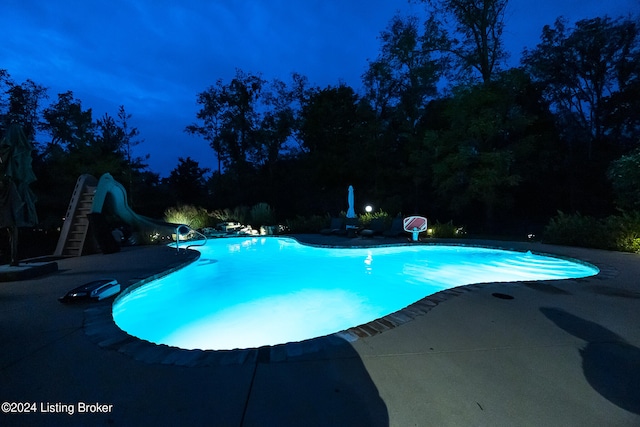 view of pool featuring a water slide and a patio