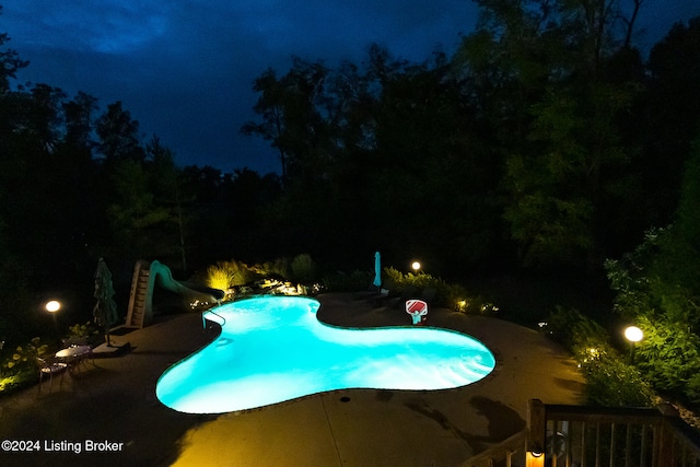 pool at twilight featuring a water slide