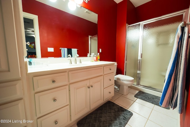 bathroom with toilet, vanity, tile patterned floors, and walk in shower