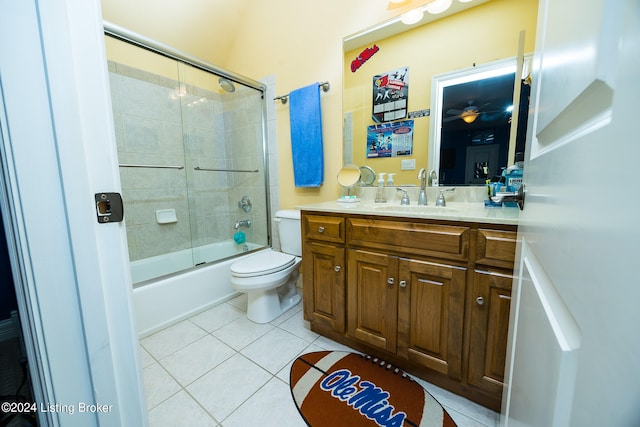 full bathroom featuring toilet, vanity, tile patterned floors, and bath / shower combo with glass door