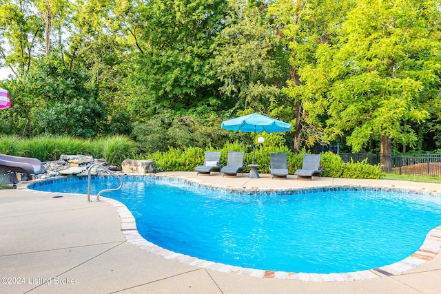 view of pool featuring a water slide and a patio